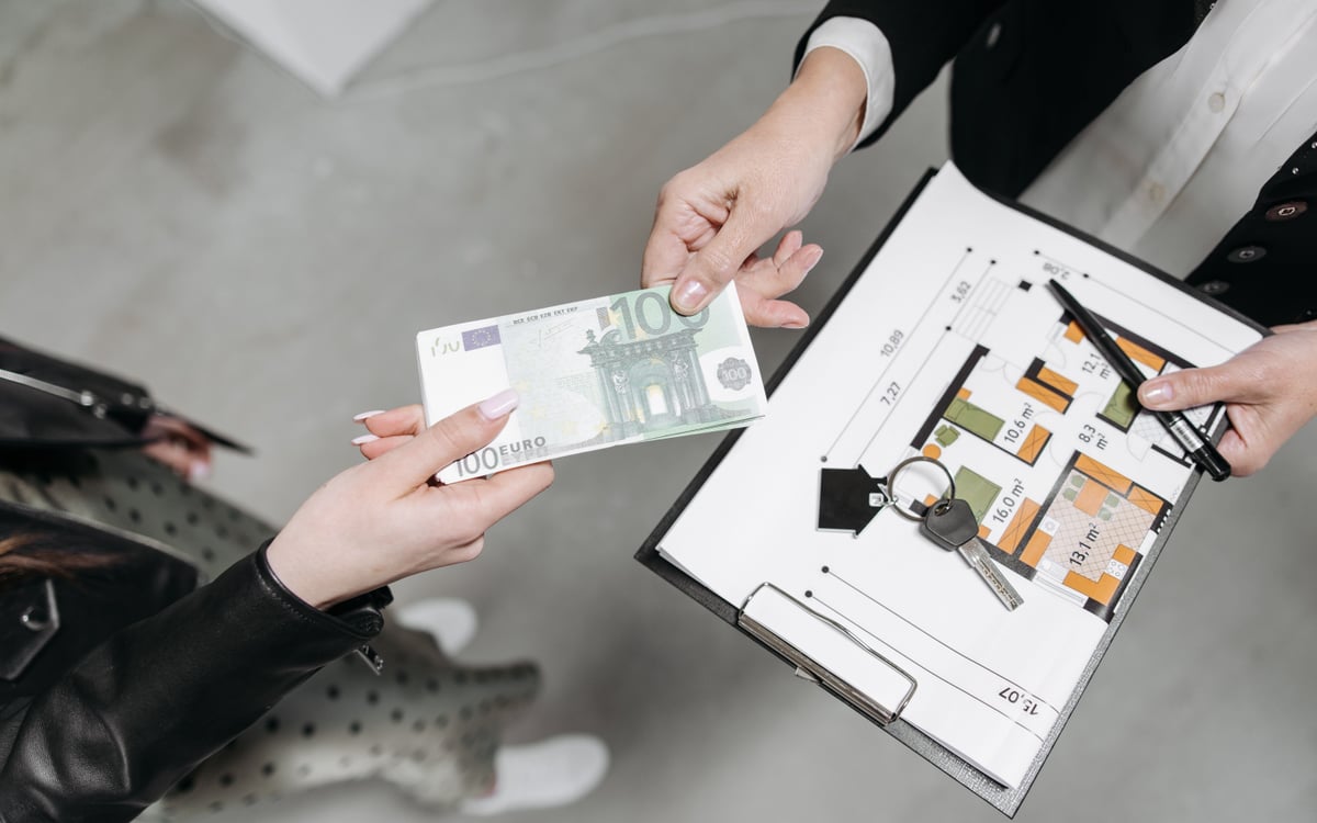 Real estate transaction with apartment floor plan, house keys, and euro banknotes